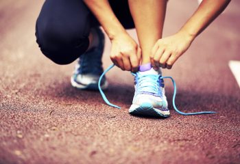 young fitness woman runner  tying shoelaces on trail
